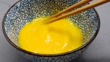 用筷子顺着一个方向快速搅打鸡蛋液。