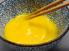 用筷子顺着一个方向快速搅打鸡蛋液。