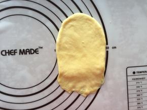 拿出一个面团擀成牛舌状，面团下面压薄一点