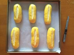 二次发酵完成后，拿出刷上蛋液，用锋利的刀划出一道口