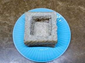 把两片吐司用刀切出方开镂空，放在完整的吐司片上，底部可铺上芝士片。