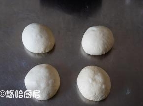 取出面团，平均分割成4份，排气后滚圆，盖保鲜膜醒发15~20分钟。
