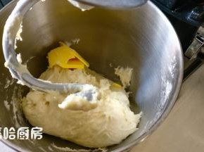 加入清水和酵母水，用厨师机低速搅拌5分钟，中速搅拌5分钟，加入室温下软化的黄油，继续搅打面团。