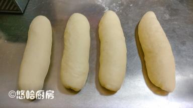 从面团的长边处卷起，依次做好全部面团，继续盖保鲜膜醒发15分钟左右。