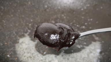 锅中留少许的底油调成小火，先倒入干黄酱与甜面酱以及绵白糖翻炒。