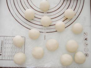 取一块水油皮在手心按成圆形，放上油酥包起来，收口朝下。