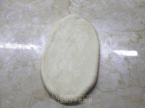 松弛好的面团擀成椭圆形。