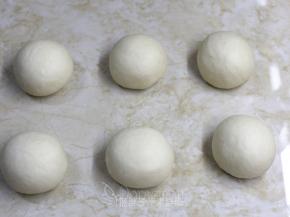 将发酵好的面团排气后分割成6份，将面团滚圆，盖上保鲜膜，松弛15分钟。