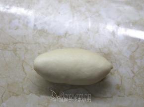 最后把剩下的1/3向上折，收口捏紧。翻过来，稍微整理一下，就是橄榄型的面团。