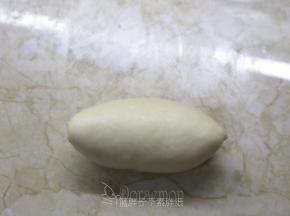 最后把剩下的1/3向上折，收口捏紧。翻过来，稍微整理一下，就是橄榄型的面团。
