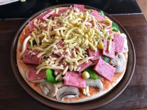 摆上口蘑，青椒，火腿和玉米粒，在上面再铺一层芝士。