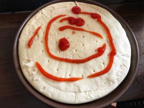 饼胚放在披萨盘里(有些披萨盘要事先刷点油)，上面挤一些番茄酱。