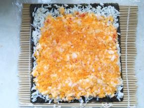 取一半咸蛋黄虾肉，均匀的铺在米饭上，并压平整
