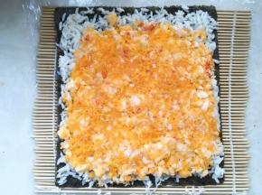 取一半咸蛋黄虾肉，均匀的铺在米饭上，并压平整
