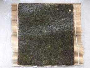 寿司竹帘上铺上一张紫菜片
