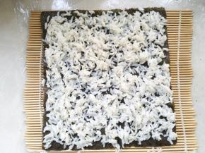 铺上一点米饭，尽量铺的均匀一些
