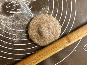 把圆面团按扁，擀成中间厚四周薄的圆片