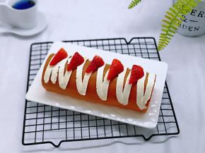 留下的奶油装入裱花袋，挤在蛋糕卷上，又装饰了草莓，这样就完成啦！