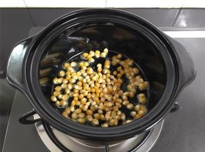 把控干水分的玉米粒放入砂锅中，用勺子拌匀，让每粒玉米都沾上黄油。