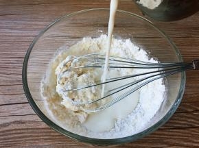 在炖菜的时候，准备奶糊，牛奶少量多次加入面粉中，并搅拌至无干粉颗粒