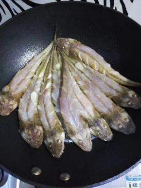 锅中放入油，烧热后放入葱姜炒香，放入鱼，煎一会