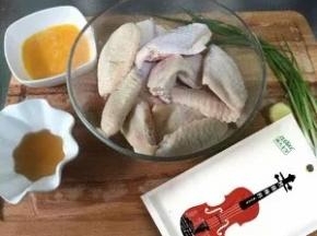 鸡翅洗干净划刀，放入葱姜酒水中浸泡一会去腥味