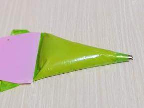 将面糊装入裱花袋，(先装入裱花嘴，再装面糊哈）用刮板将面糊往前推，如图。