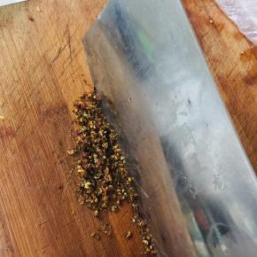 把刚刚炸过的花椒用刀剁成花椒末备用。