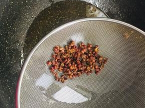 锅烧热倒入适量的油，放入花椒小火煸炒出麻味儿，把花椒捞出来沥干油分备用。
