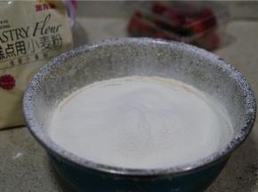 然后将金龙鱼糕点用小麦粉过筛加至蛋黄里面，因为用到的面粉量微多，所以过筛一下有助于拌制。