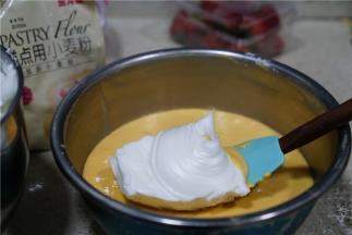 然后分次将拌好的蛋白糊加至到蛋黄糊里面。
