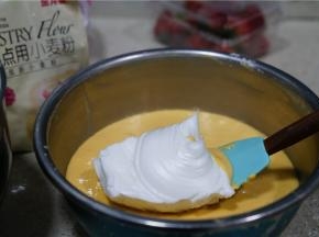 然后分次将拌好的蛋白糊加至到蛋黄糊里面。