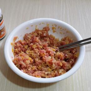 将切碎的酸菜放入肉糜中，再次搅拌均匀。