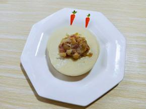 可以包饺子啦！取一张饺子皮，放上肉馅。