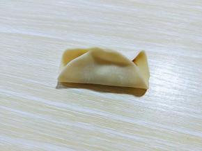 先对折，捏紧，如图。