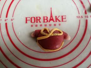 黄色面团搓成细长条，如图摆放，用水粘牢，做成过年唐装样式