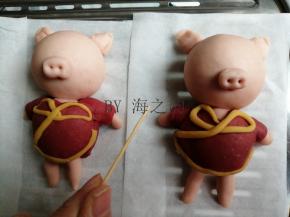 用粉色面团做出耳朵和鼻子，鼻孔和嘴巴都用牙签戳出