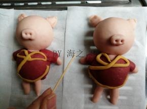 用粉色面团做出耳朵和鼻子，鼻孔和嘴巴都用牙签戳出