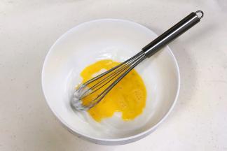 往猪油内加入鸡蛋液，用手动打蛋器稍微拌拌。