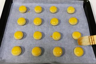 依次摆入烤盘中，刷上蛋黄液。