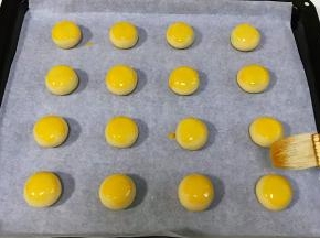 依次摆入烤盘中，刷上蛋黄液。