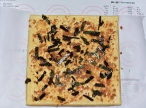 撒上剩余肉松和海苔，用擀面杖辅助卷起