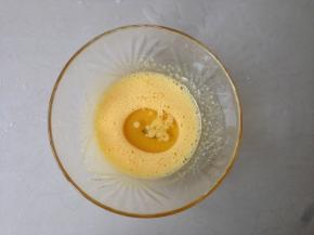 3个蛋黄加入10克糖，用蛋抽搅拌至糖融化。倒入玉米油，搅拌均匀