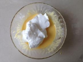 蛋清分3次加入30克糖，用电动打蛋器打发至偏干性发泡。将三分之一打发好的蛋白霜加入到蛋黄糊里，从两点钟方向切入，沿着盆壁从8点钟方向向上翻拌，左手逆时针转动打蛋盆