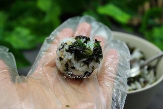 戴上手套，用勺子挖一勺饭放在手心，揉搓光滑的小饭团。喜欢吃当的饭团的可以用两勺饭。如果是小孩吃建议做小个饭团，方便吃。