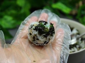 戴上手套，用勺子挖一勺饭放在手心，揉搓光滑的小饭团。喜欢吃当的饭团的可以用两勺饭。如果是小孩吃建议做小个饭团，方便吃。