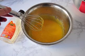 用手动打蛋器打散蛋黄，然后加入50克玉米油。