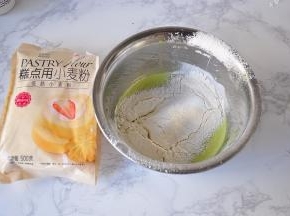 将金龙鱼低筋小麦粉过筛到拌好的蛋黄糊中。
