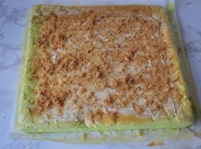 待蛋糕放凉，底部垫油纸再扣回来，抹上一层沙拉酱，再撒上肉松