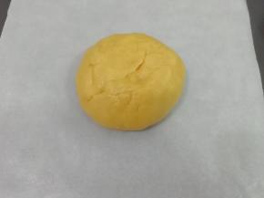 饧好的面团取出来，底部放入一张油纸